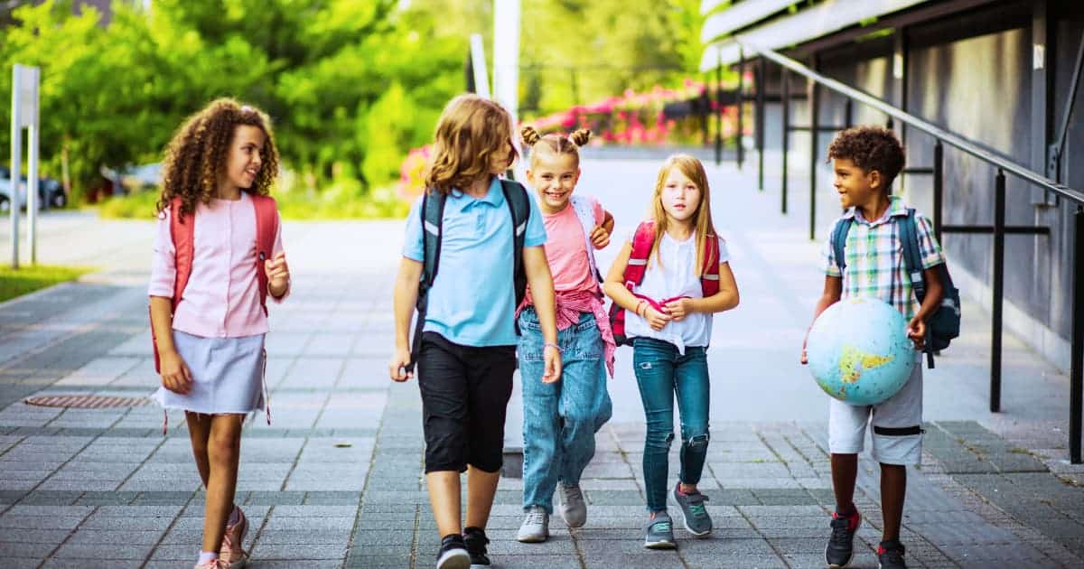 Happy young middle school student walking inside their school