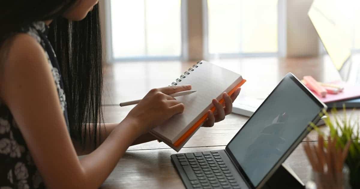 Student typing on a laptop, symbolizing the writing process for college essays.