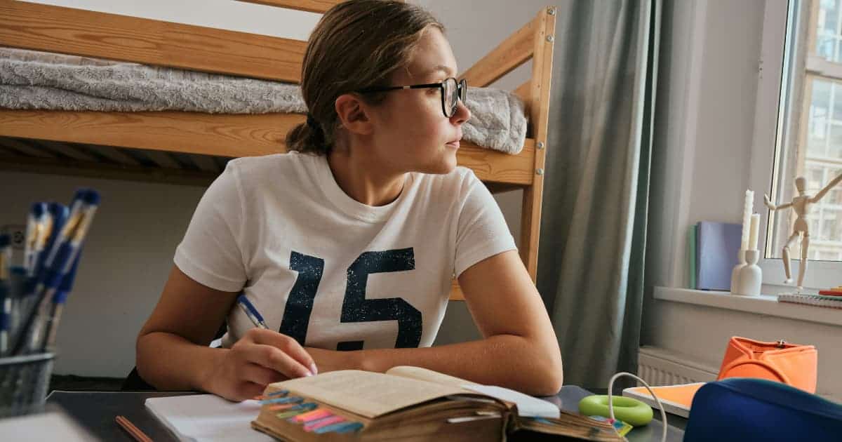 A thoughtful student with a notebook, symbolizing planning for college preparation.