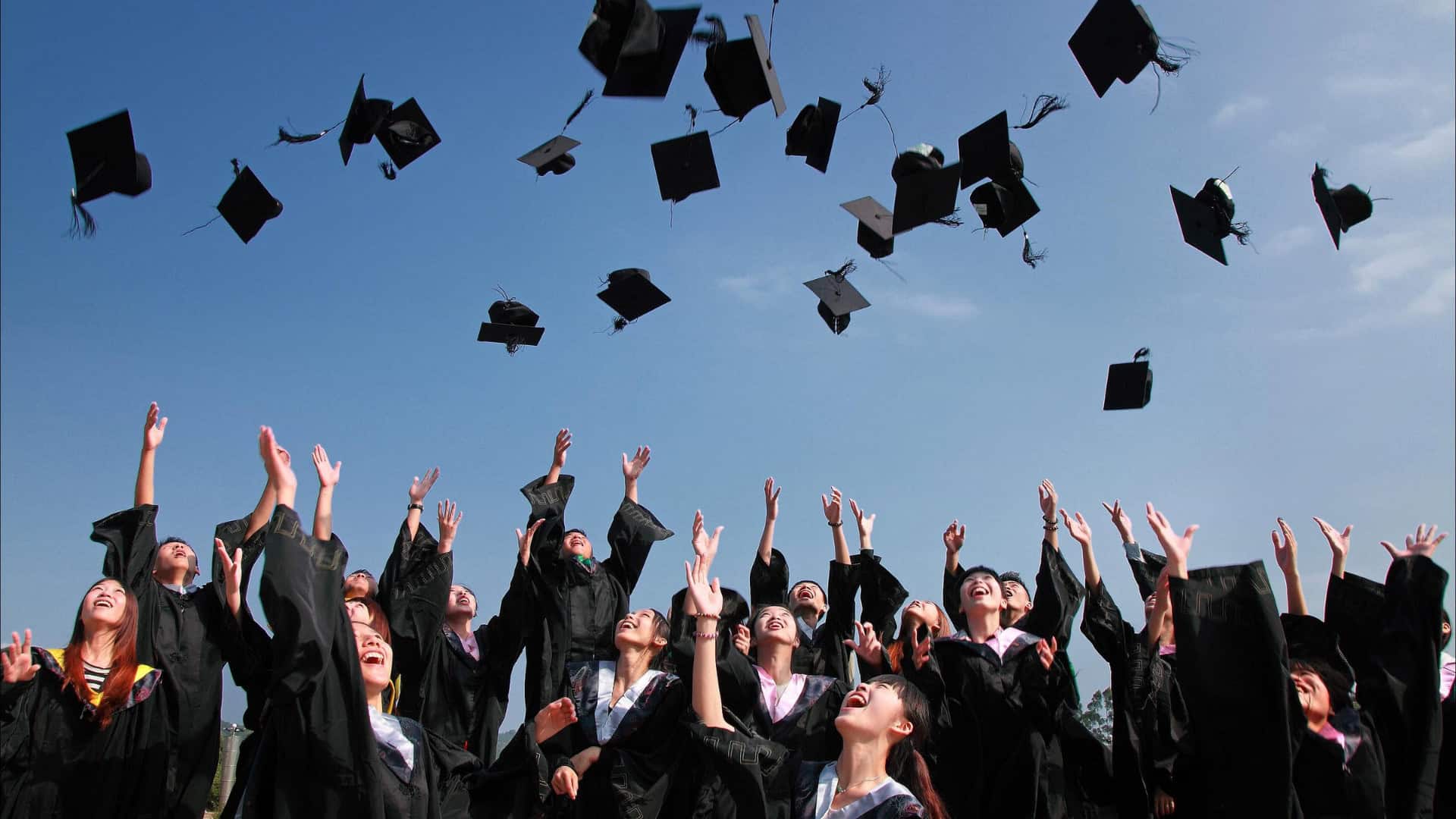 group of students throwing caps on their graduation day