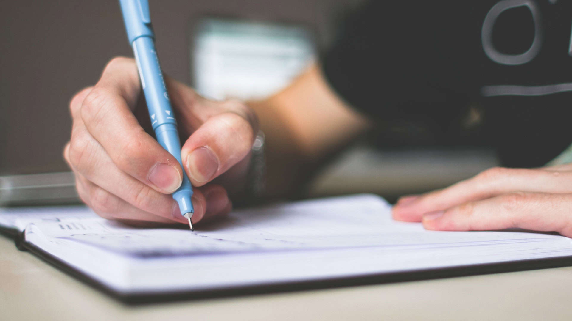 student working on her letter to tell college they are their first choice